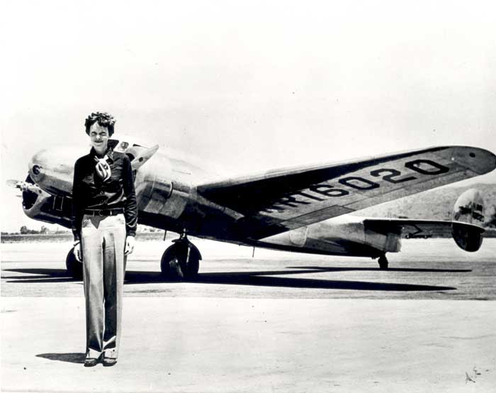 Amelia Earhart berdiri di depan pesawat Lockheed Electra. 